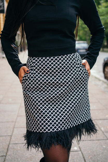 beautiful black haired lady in a black top nad black and white feather skirt - this is a two piece dress, that can be split into top and skirt