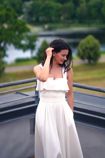 beautiful brunette in a white two piece dress - a ruffled corset top and wide flowy skirt