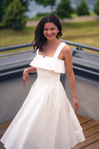 beautiful brunette in a white two piece dress - a ruffled corset top and wide flowy skirt