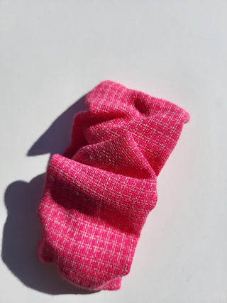 fuchsia pink hair clip on a white table