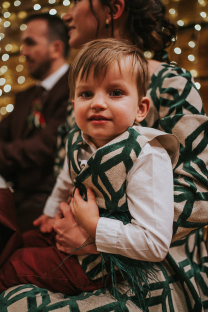 baby boy sitting in the lap on his mother, having matching outfits