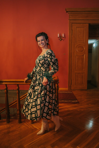 lady in a red room and emerald green three piece dress with feathers