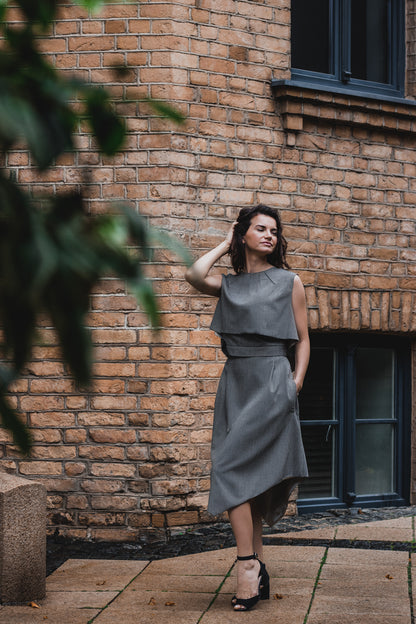 beautiful woman on a sunny day, wearing three piece dress - two tops and gray brown triangle skirt together with black heels