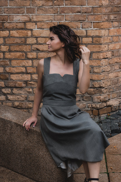 beautiful brunette on the streets in a gray two piece office dress - a corset top and a triangle skirt