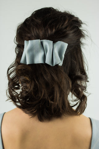 light blue hair clip pinned in the hair