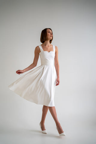 beautiful woman in a white two piece dress with corset top and long flowy skirt in white heels